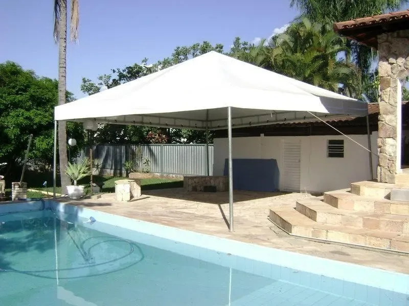 Tenda piramidal branca ao lado de piscina